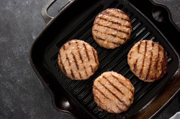 Gekookte rundergehaktpasteitje op grillpan. Zelfgemaakte hamburgers koken.