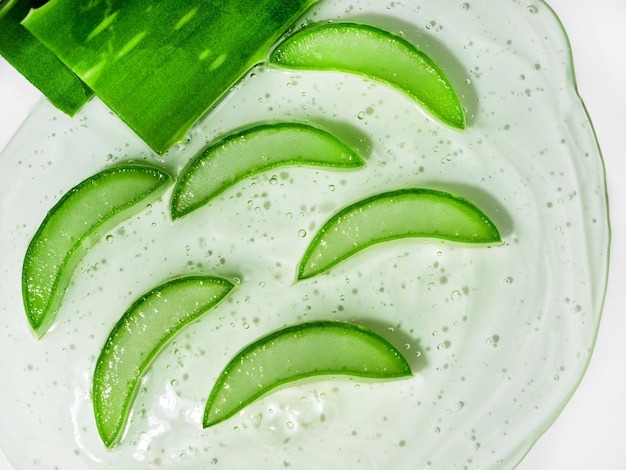 Foto gel con fettine di succosa aloe vera. siero viso, cura della pelle. vista dall'alto, copia dello spazio.