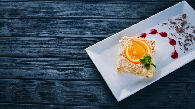 Gelaagde cake met sinaasappelsmaak op een houten ondergrond vrije ruimte voor uw tekst bovenaanzicht