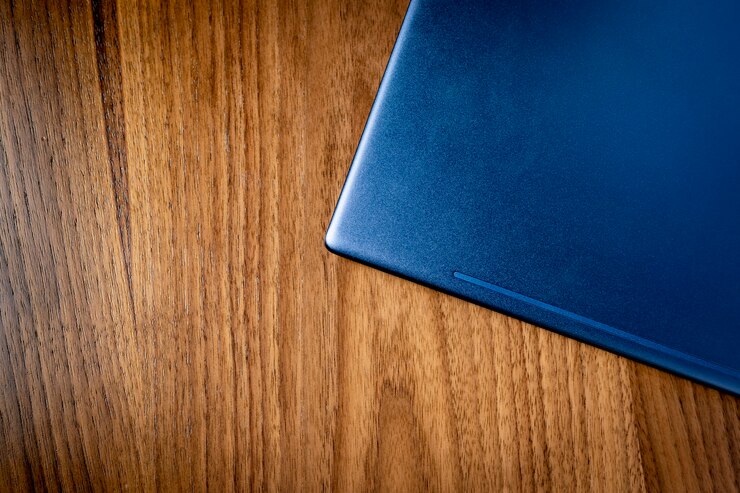 Gelakt houten tafel met gesloten blauwe laptop - kopieer ruimte.