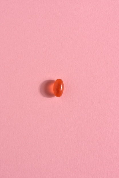 Gelatin capsule pill on pink