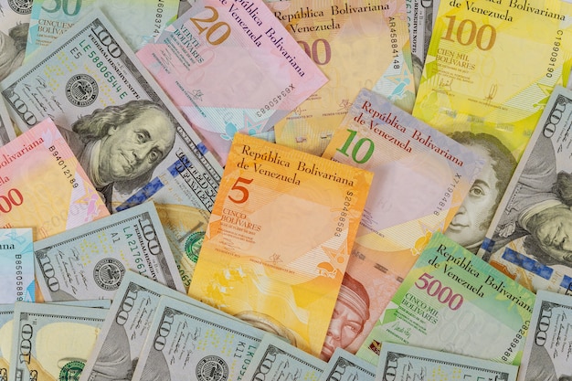 Geld Amerikaanse honderd-dollarbiljetten serie bankbiljetten met verschillende papieren biljetten valuta Venezolaanse Bolivar, Venezuela economische crisis
