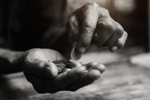 Geld Munten Opa's Pensioen en Minimal Life Concept Oude opa verzamelt helaas een kleine munt op een houten tafel