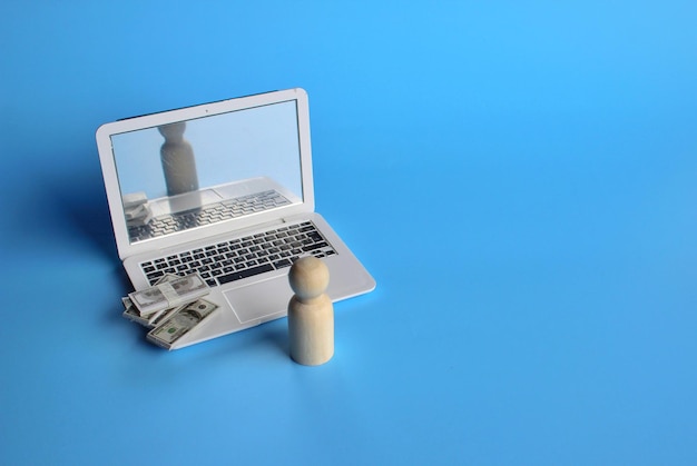 Geldoverdracht en online zaken houten pop voor laptop en stapel geld ruimte kopiëren