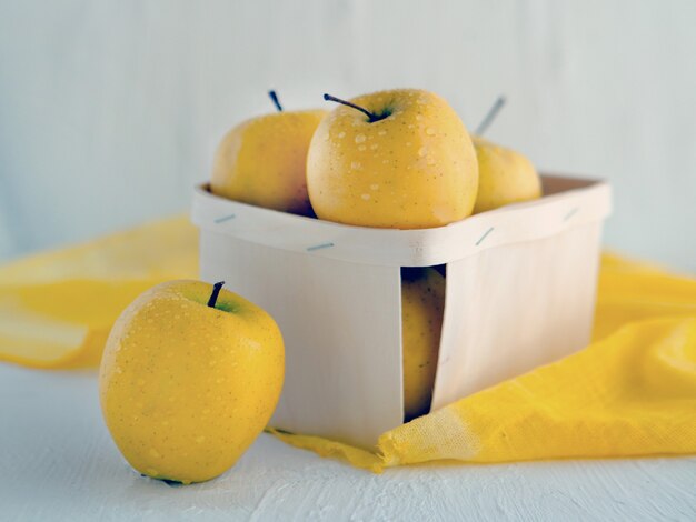 Gele appels bij de mand op witte achtergrond Symbolisch beeld Concept voor gezonde voeding