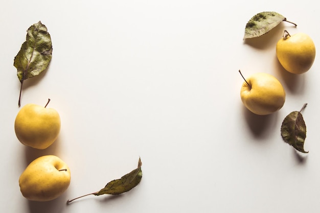 Gele appels op een witte achtergrond met oude bladeren, gezond voedsel, landbouw, vegetarisme