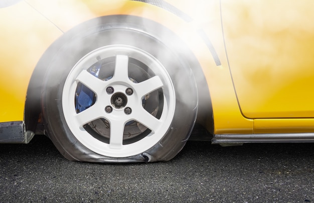Gele auto die een lekke band op roas heeft