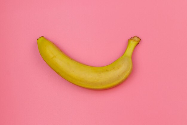 Gele banaan op roze achtergrond Bovenaanzicht plat lag minimaal ontwerp