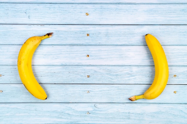 Gele bananen liggen op een blauwe houten achtergrond. Zomer concept