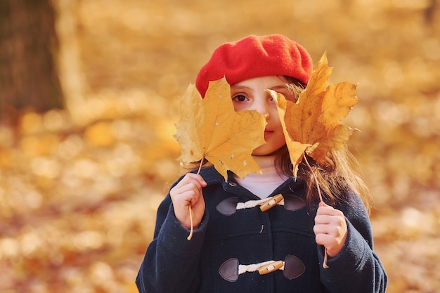 Foto gele bladeren leuk positief meisje veel plezier in het herfstpark