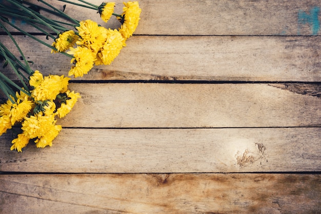 Gele bloemen van boeket, bovenaanzicht op houten achtergrondstructuur met kopie ruimte