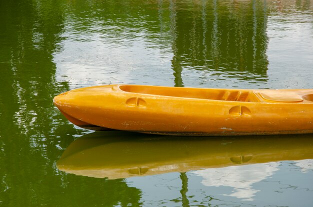 Gele boot die op de vijver drijft