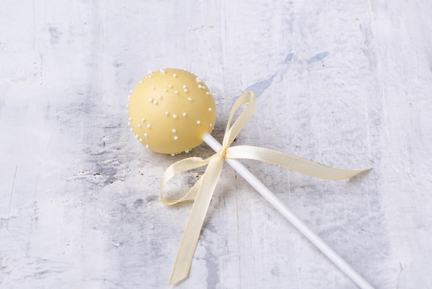 Gele cakepop op een gestructureerde achtergrond