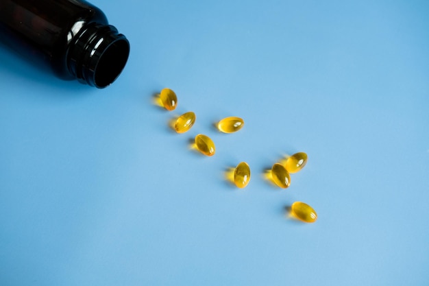 Gele capsules visolie op een blauwe achtergrond Nuttige vitamines Zorgen voor je gezondheid