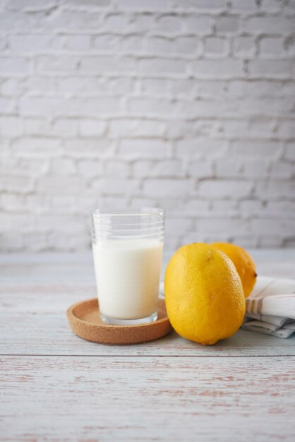 Gele citroen en glas melk op tafel
