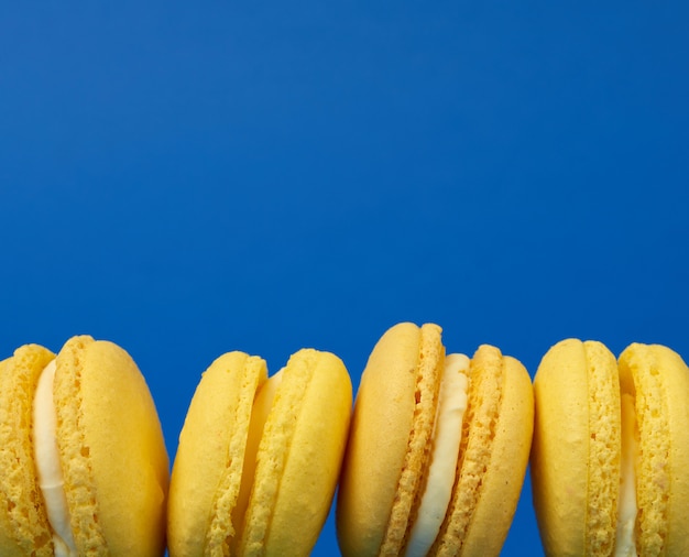 Gele citroen ronde gebakken macaroon cakes op een donkerblauwe achtergrond