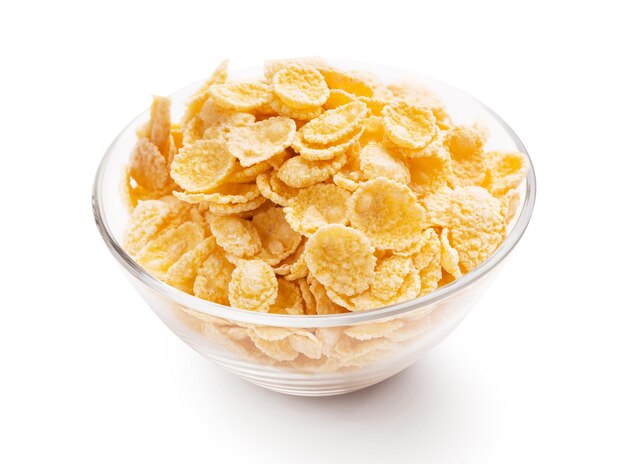 Gele cornflakes in glazen kom op witte achtergrond