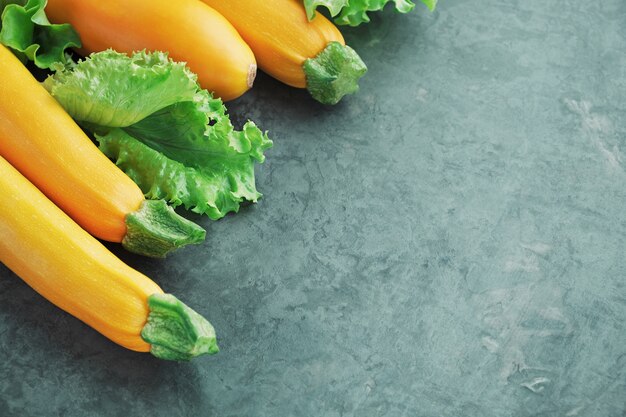 Gele courgette en sla op keukentafel