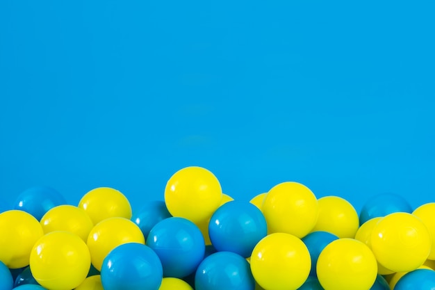 Gele en blauwe plastic ballen in pool van speelkamer