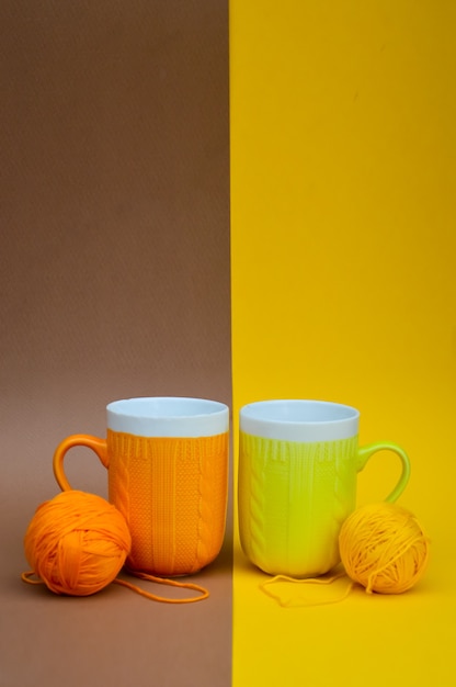 Gele en oranje cups met een gebreid patroon op een bruingele ondergrond