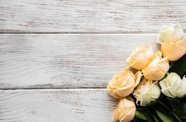 Gele en witte rozen op een oude houten tafel