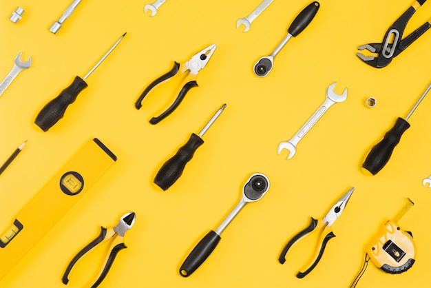 Gele en zwarte handige tools (pilers en schroevendraaier) geïsoleerd op gele achtergrond