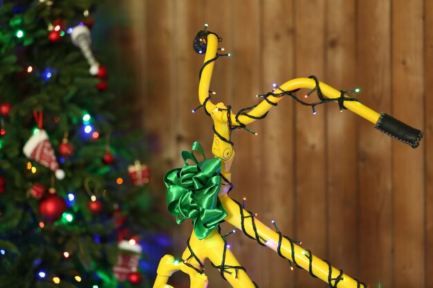 Gele fiets dichtbij Kerstboom