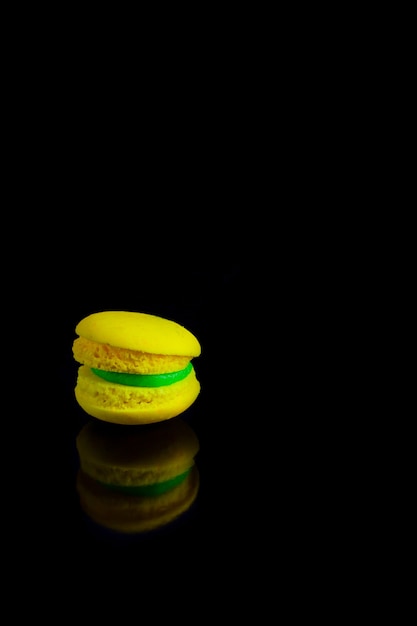 Gele franse bitterkoekjes op een zwarte achtergrond.