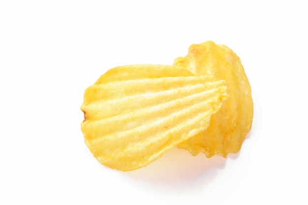 Gele gegolfd gezouten twee chips op een witte ondergrond, close-up