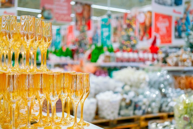 Gele glazen bekers op een wazige kerstachtergrond met feestelijke goederen.