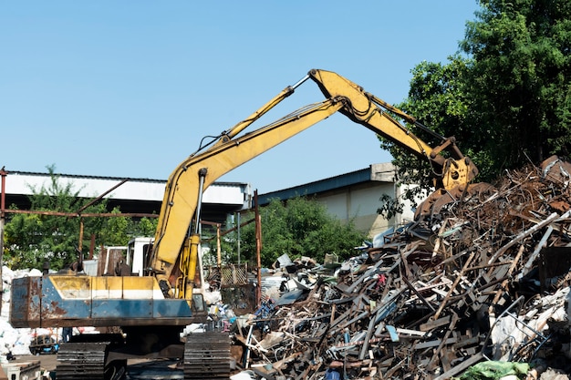 Gele graafmachine in recyclingfabriek