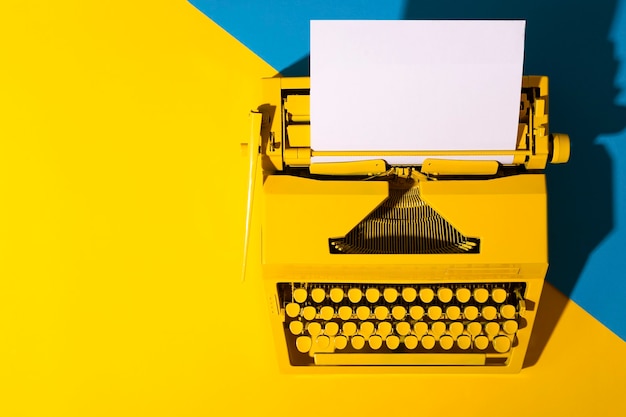 Gele heldere typemachine op een geel en blauw oppervlak