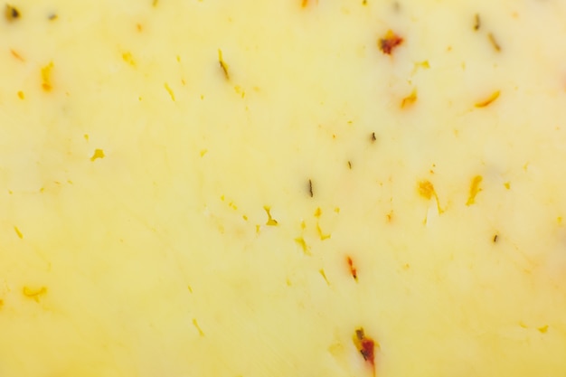 Gele kaas met kruiden en specerijen achtergrond Textuur. Sluit omhoog, macrofoto.