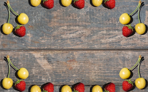 Gele kers en rode aardbei op houten textuurplanken Landelijk tuinieren moestuinvruchten