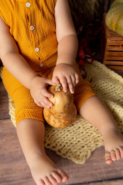 gele kleine pompoen in de handen van een kind