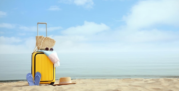 Foto gele koffer met stranditems op zandige kustruimte voor tekst