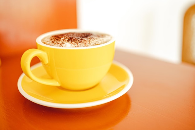 Gele koffiemokken op houten tafel in café