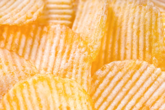 Gele krokante geribbelde chips close-up Voedsel achtergrond