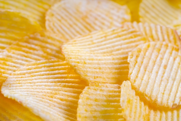 Gele krokante geribbelde chips close-up Voedsel achtergrond