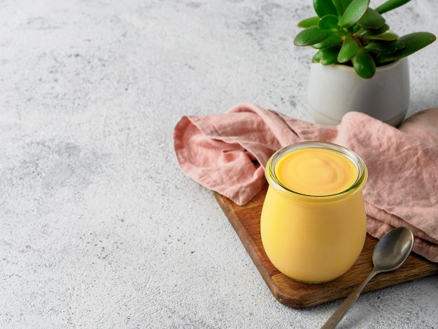 Gele mango lassi op grijze achtergrond. indiase mango-yoghurtdrank met kopieerruimte over.