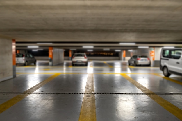 Gele markeringen met vage moderne auto's geparkeerd in gesloten ondergrondse parkeerplaats.