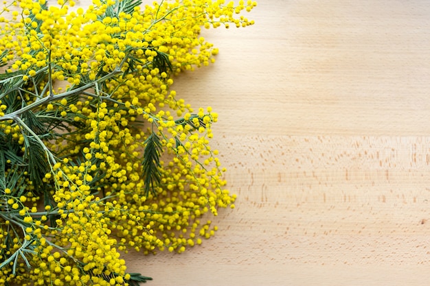 Gele mimosabloemen op de natuurlijke houten achtergrond