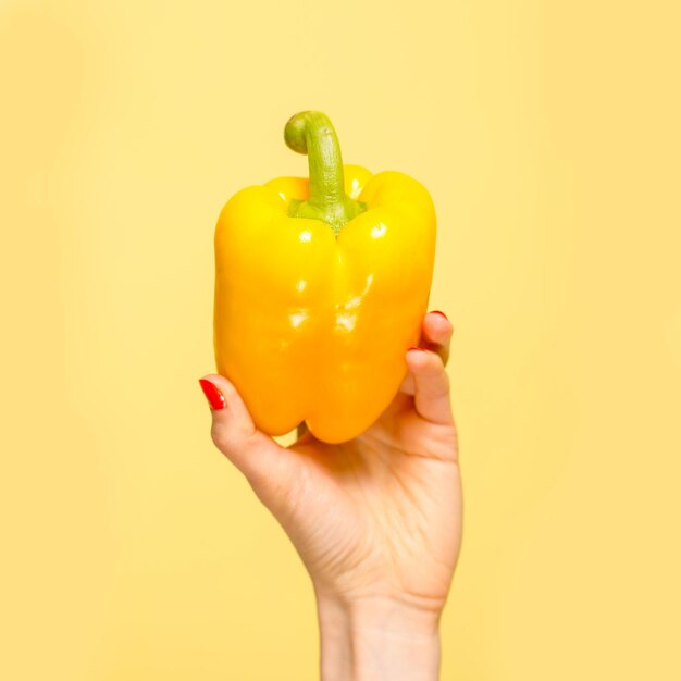 Gele paprika in de hand Geel op geel