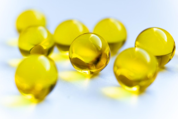 Gele pillen op een witte achtergrond Vitaminen A en E capsules close-up Ronde gele pillen