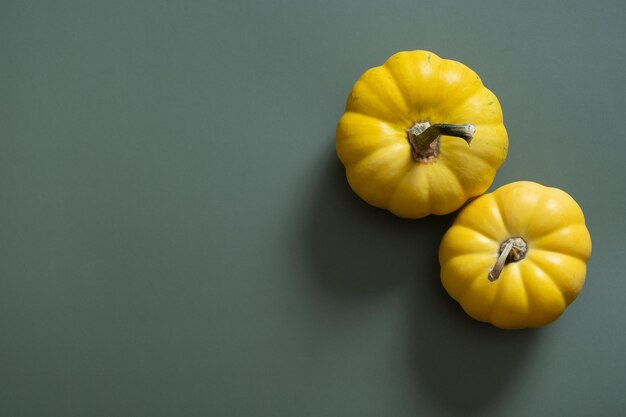 Gele pompoenen op groene achtergrond Herfst minimalistische esthetische stilleven
