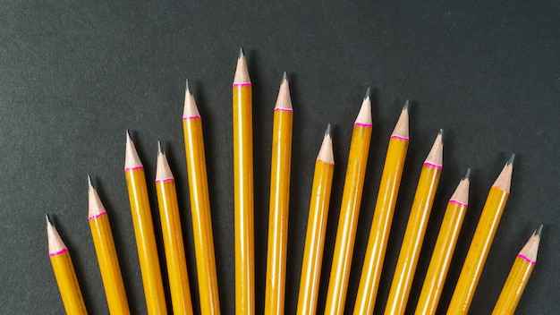Gele potloden op zwarte achtergrond Terug naar schoolachtergrond