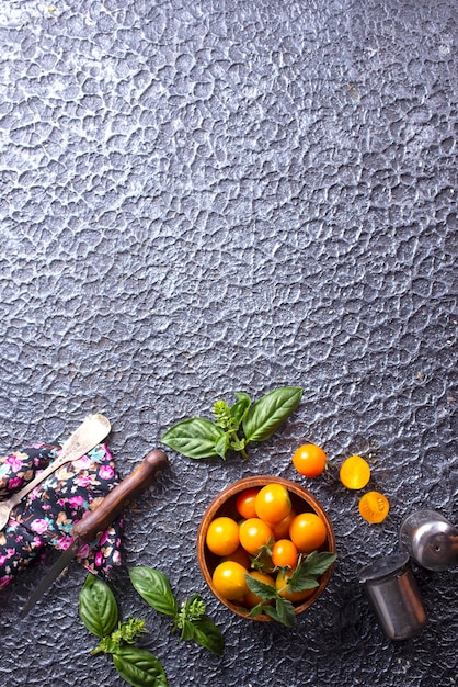 Gele rijpe tomaten in een houten kom op een stenen achtergrond