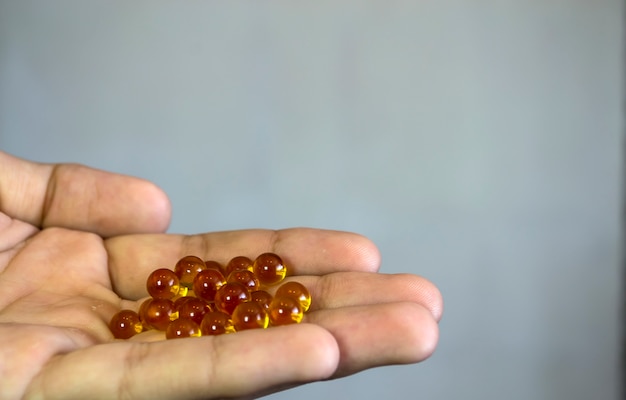 Gele ronde tabletten op de hand op een witte achtergrond