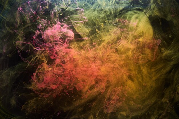 Gele rook op zwarte achtergrond kleurrijke mist abstracte wervelende inkt oceaan zee acrylverf pigment onderwater