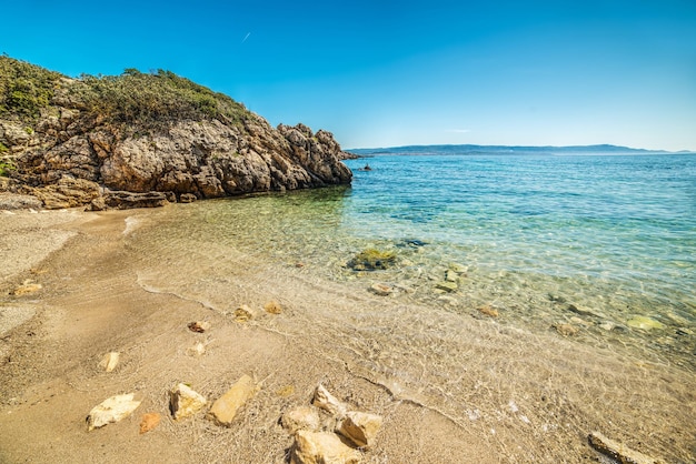 Gele rotsen in een kleine baai in Sardinië Italië